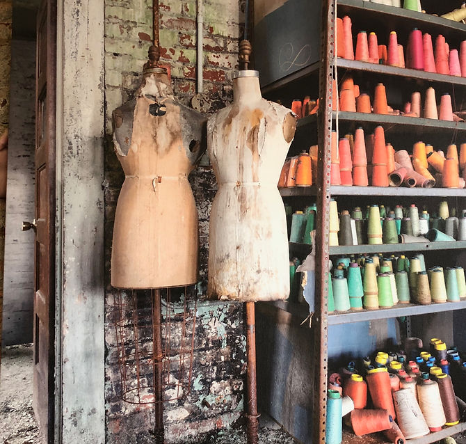 Vintage tailor workshop with dress forms and colorful thread spools